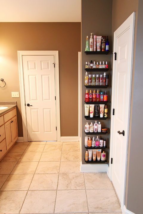 Easy DIY Bathroom Organization! Use crown molding to make shelves to organize perfumes, lotions, hairspray, etc. Neat, organized, and right at your fingertips! From kevinandamanda.com 