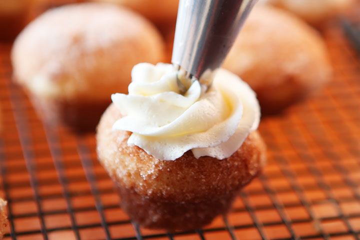 Strawberry Shortcake Doughnut Muffins. These are like little bites of HEAVEN. A muffin that tastes like a doughnut, dunked in brown butter and rolled in cinnamon sugar for a sweet, crunchy crust. Then topped with buttercream frosting and fresh cut strawberries. Amazing.