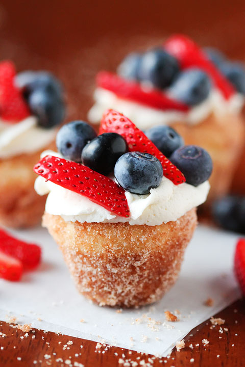 Strawberry Shortcake Doughnut Muffins. These are like little bites of HEAVEN. A muffin that tastes like a doughnut, dunked in brown butter and rolled in cinnamon sugar for a sweet, crunchy crust. Then topped with buttercream frosting and fresh cut strawberries. Amazing.