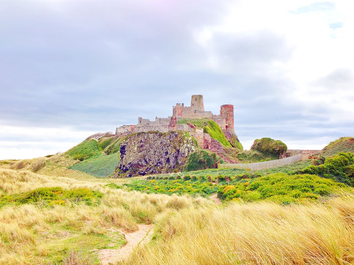 Visit Bamburgh Castle on a castle drive down the coast of Scotland + More Tips for Traveling to Scotland from www.kevinandamanda.com.