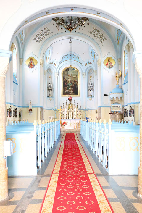 Inside of the Blue Church with a red carpet down the center aisle