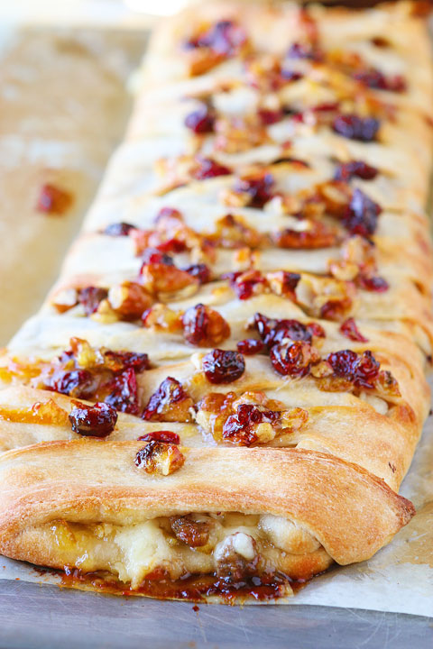 This beautiful Harvest Breakfast Braid is perfect for breakfast, brunch, or even dinner! Layers of sausage, apple, and havarti cheese make for the perfect sweet and salty combo. It's all topped with cranberries and pecans in a sweet orange marmalade glaze. 