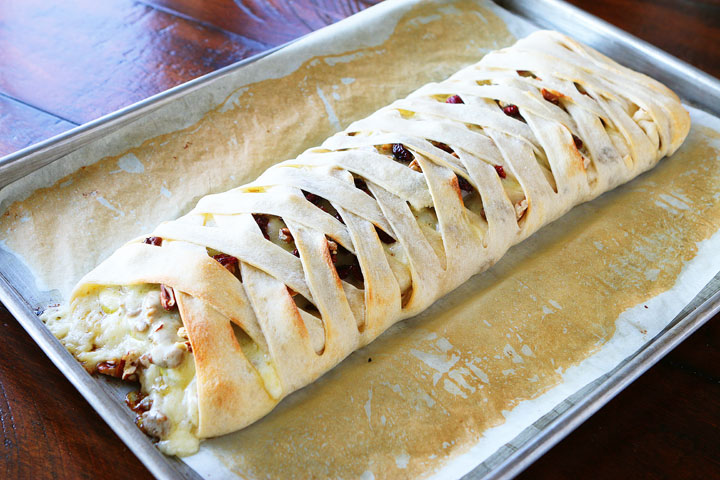 This beautiful Harvest Breakfast Braid is perfect for breakfast, brunch, or even dinner! Layers of sausage, apple, and havarti cheese make for the perfect sweet and salty combo. It's all topped with cranberries and pecans in a sweet orange marmalade glaze. 