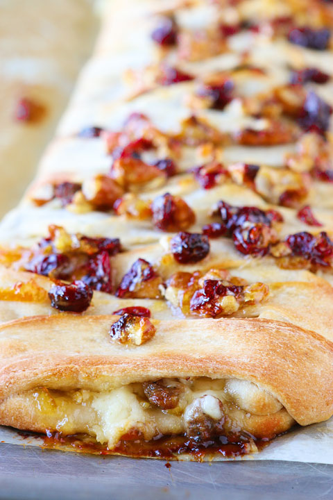 This beautiful Harvest Breakfast Braid is perfect for breakfast, brunch, or even dinner! Layers of sausage, apple, and havarti cheese make for the perfect sweet and salty combo. It's all topped with cranberries and pecans in a sweet orange marmalade glaze. 