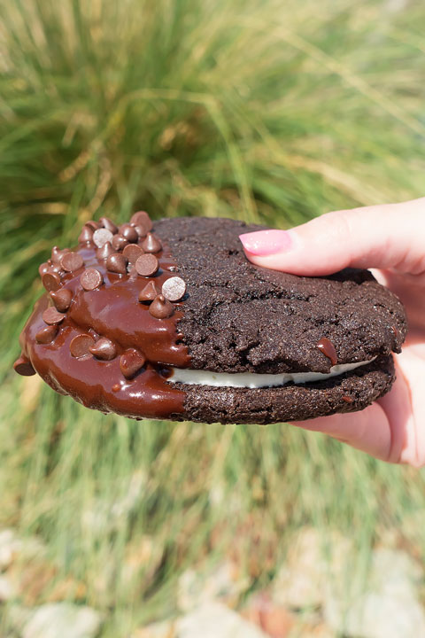 Image of a Chocolate Dipped Double Chocolate Chip Cookie Sandwich From Sassy's Bakery Case
