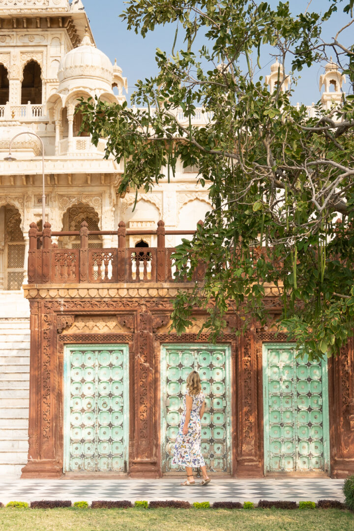 Woman walking in front a blue gate in Jodhpur, India