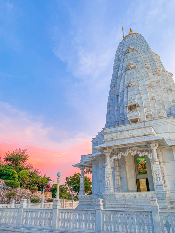 The modern Birla Temple in front of a blue and pink sunset. 