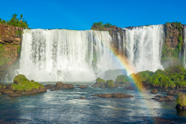 Photo of Iguazu Falls from Brazil with a rainbow in the mist.