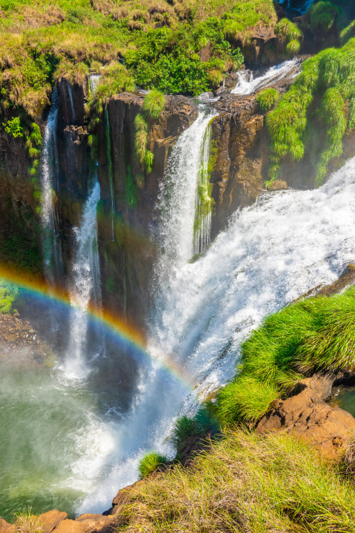 View of Iguazu Falls from Argentina with a rainbow in the mist.