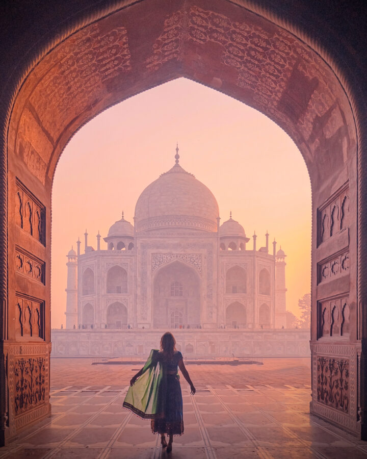 Amanda looking up at the Taj Mahal from under and archway in the early morning light.