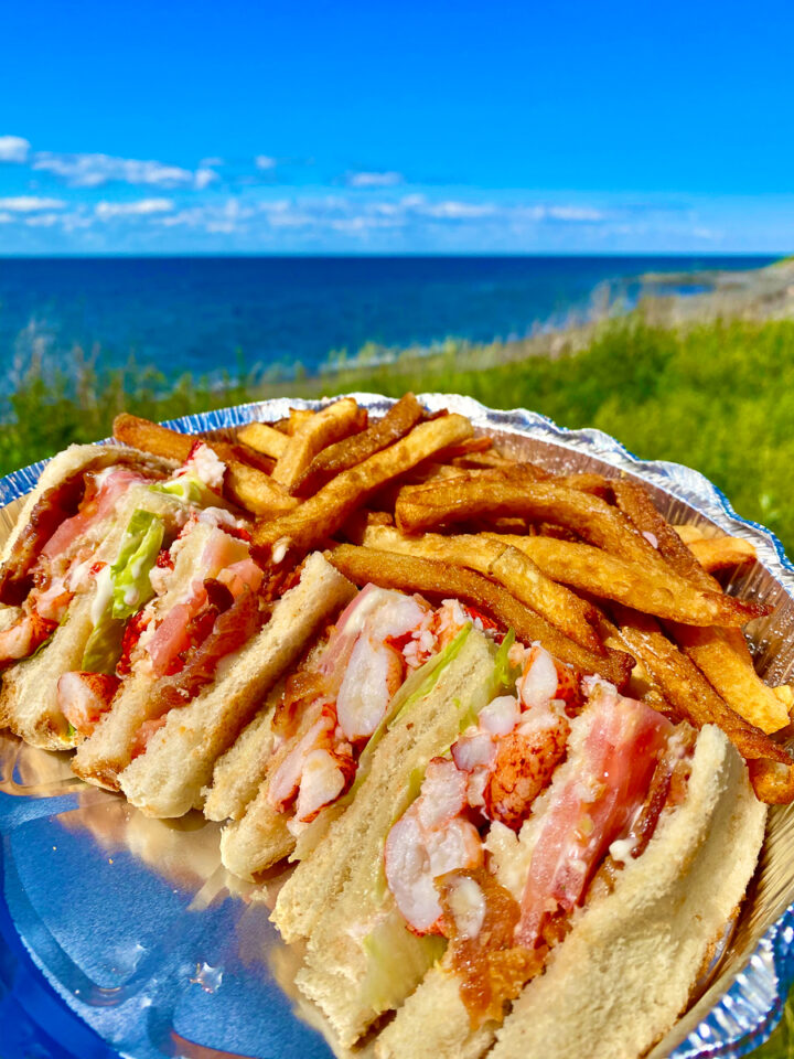 lobster club sandwich with poutine on the beach in Gaspesie