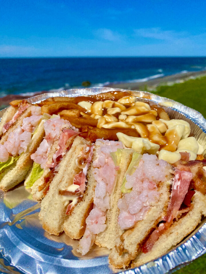 shrimp club sandwich with poutine on the beach in Gaspesie