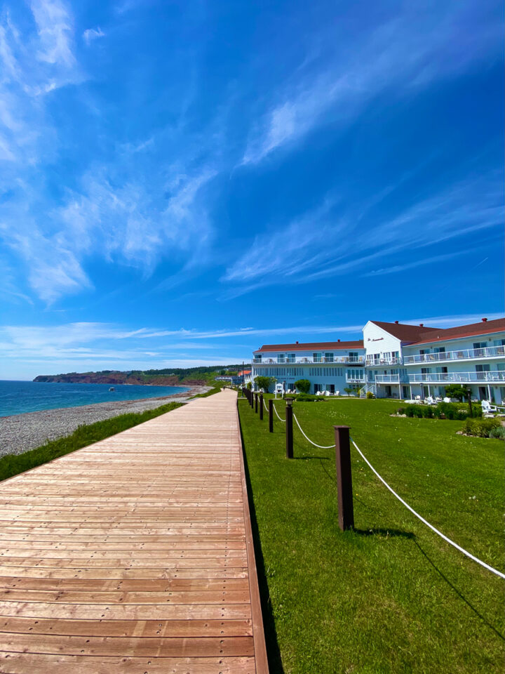 boardwalk in perce, quebec with la normandie hotel in background